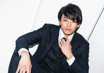 Mr. Akisato Takasho is wearing a black suit and is sitting, he is a Japanese & Asian model, actor, talent, singer, and dancer.